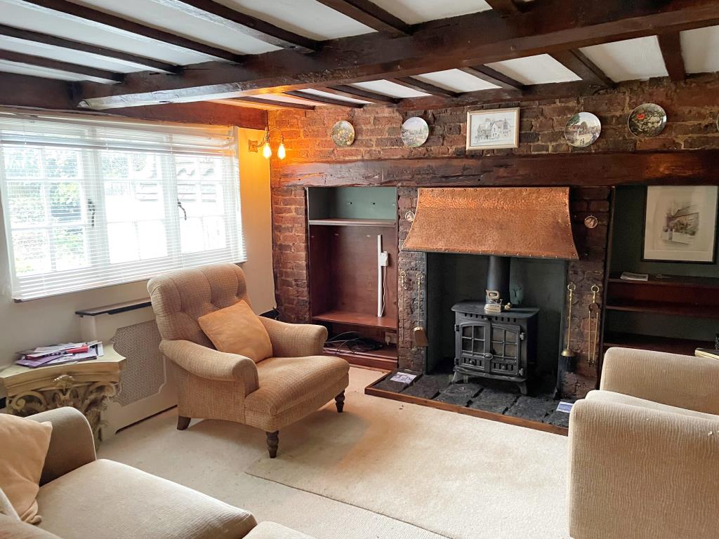 Lot: 10 - CHARACTER COTTAGE WITH GARAGE AND GARDENS - view of living room with beams and fireplace